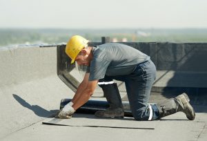 A picture of a roofing contractor repairing a flat roof