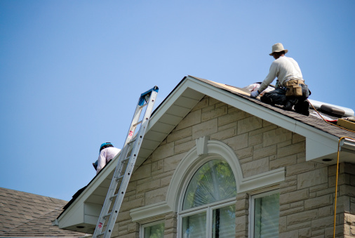 Workers installing new roof on a home