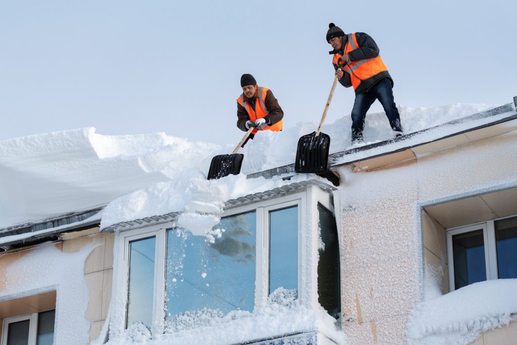 roofing company in barrie removing snow from the roof