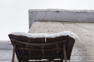 Snow covers an old table in winter, viewed from below.