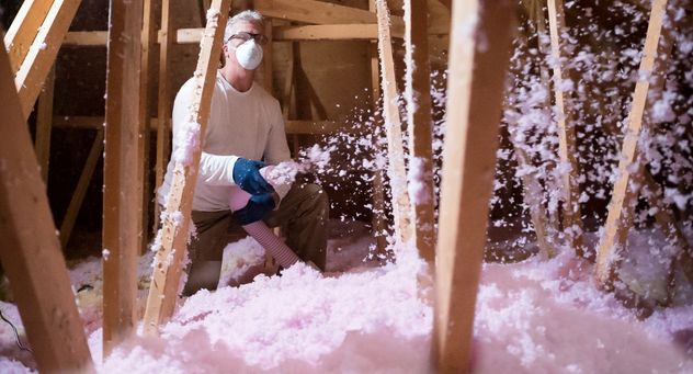 Attic insulation contractor, filling an attic in Orillia, Ontario with blown-in attic insulation
