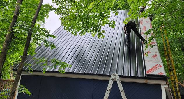 Roofer installing metal roof in parry sound
