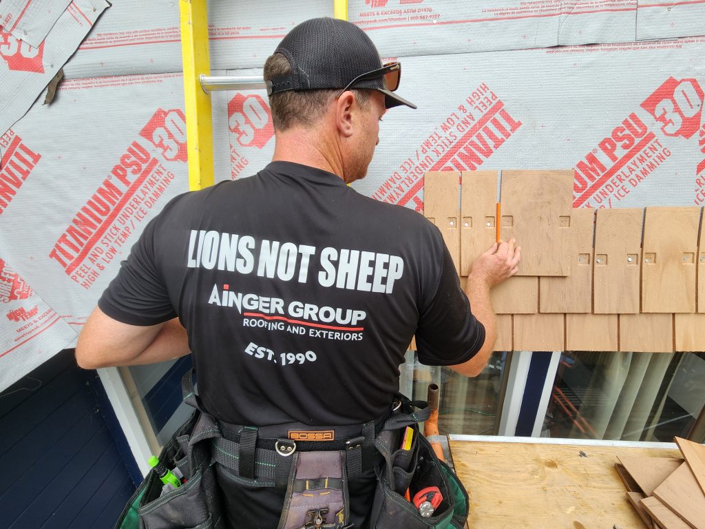 Muskoka roofing company installs Siding, while wearing a Lions not sheep Ainger T-Shirt
