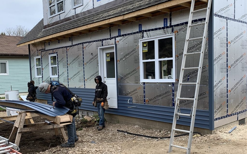 Ainger crew installing residential siding over a prepared wall system.